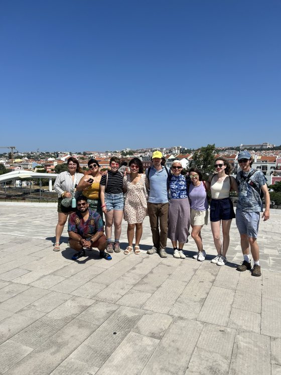 A group of people with their arms around each other smiling at the camera.
